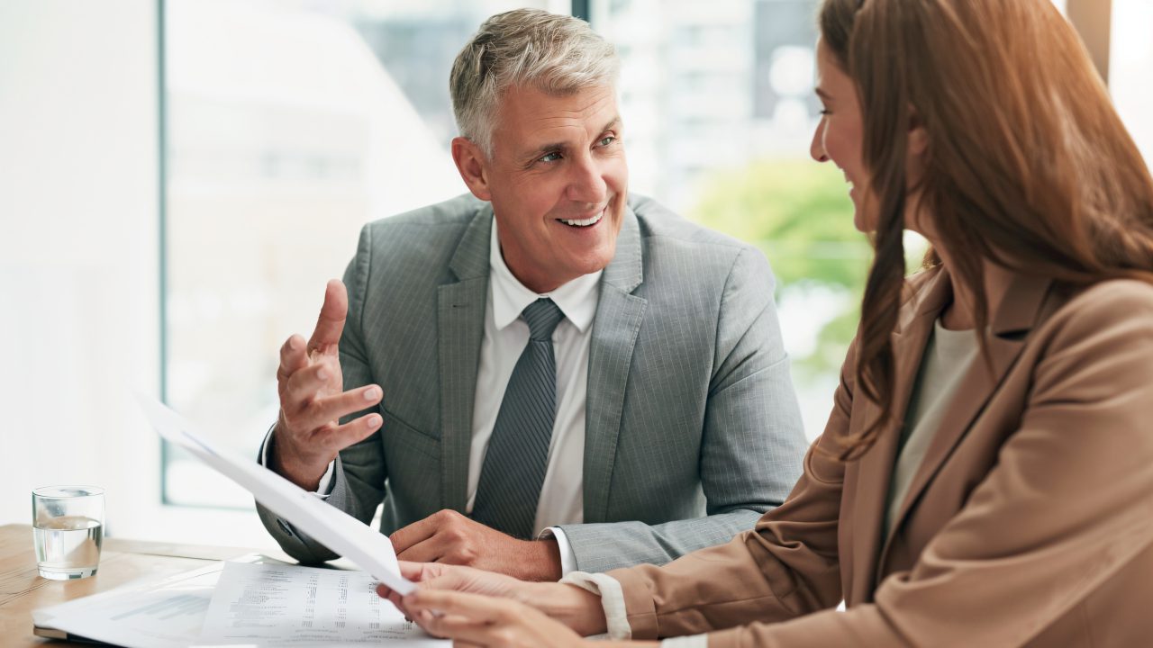 Man and woman discussing business documents.