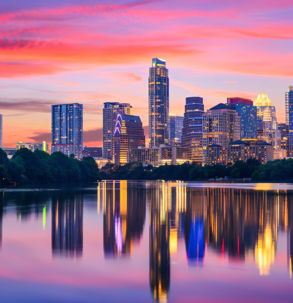 City skyline with colorful sunset reflections.