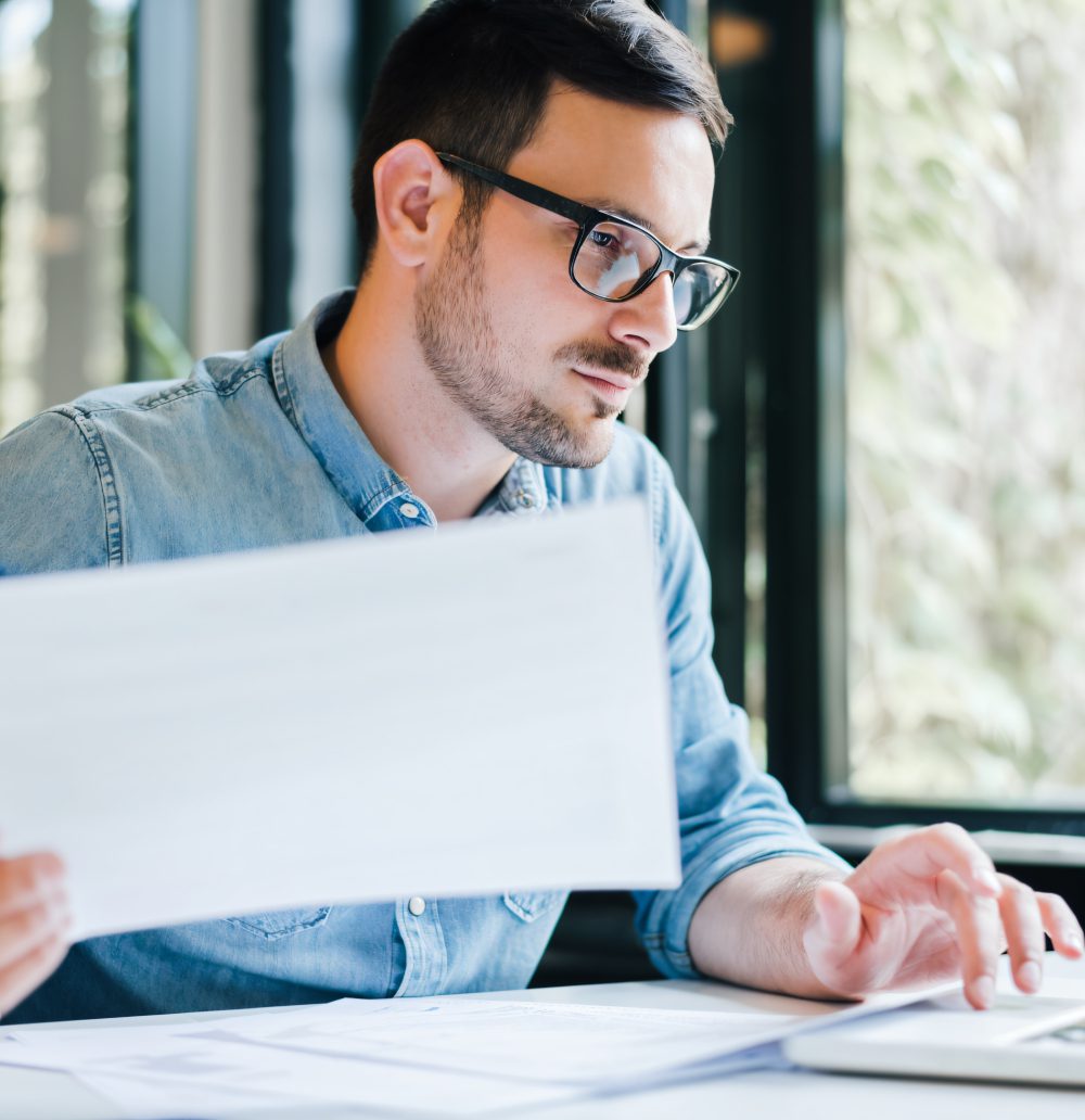 Man in glasses working at desk.
