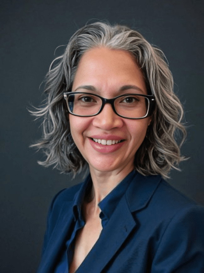 Smiling woman with glasses and gray hair.