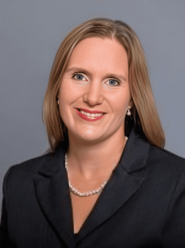 Smiling woman in a dark suit portrait.