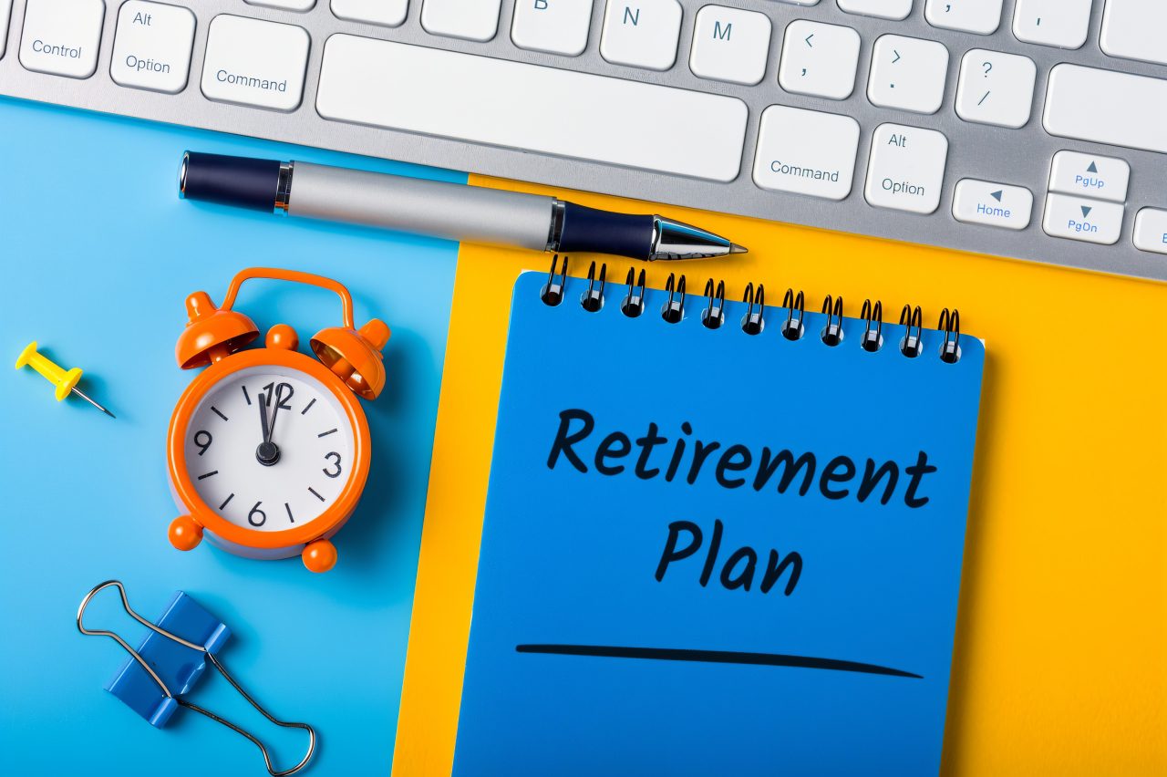 Retirement plan notebook with clock and pen.